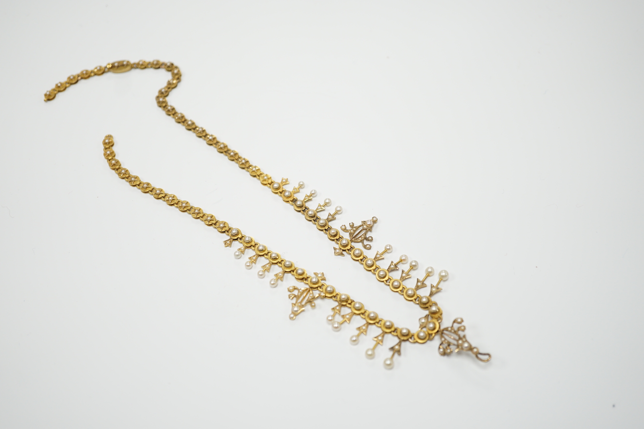An Edwardian yellow metal and seed pearl set necklace, lacking drops and clasp, 39cm, gross weight 26.2 grams.